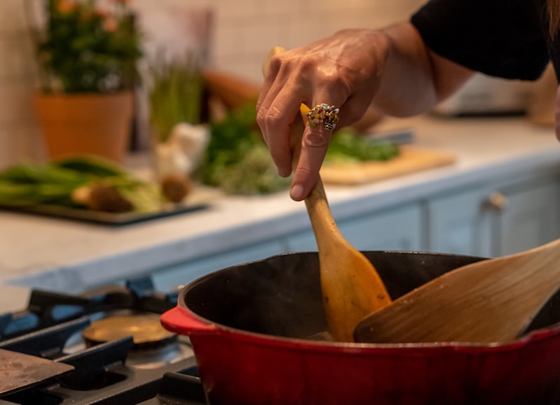 A volunteer at a community kitchen plates a hot meal for the next person in line.