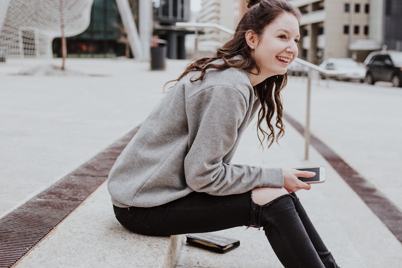 A person checks off items on a phone-based planner while sitting at a bus stop.